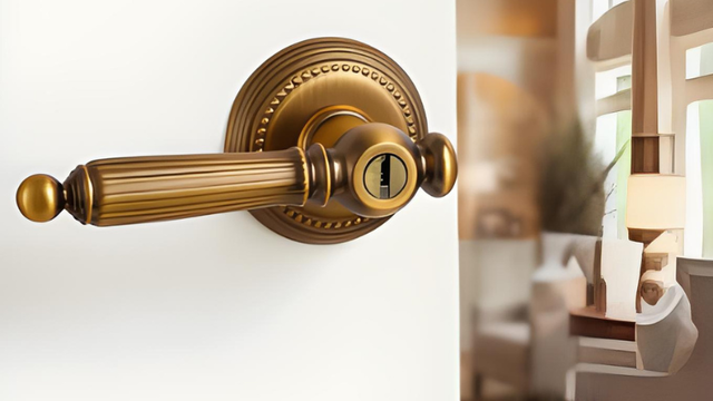 Béquille cannelée vintage sur rosace perlée avec cylindre à clé, finition bronze brossé, sur une porte blanche