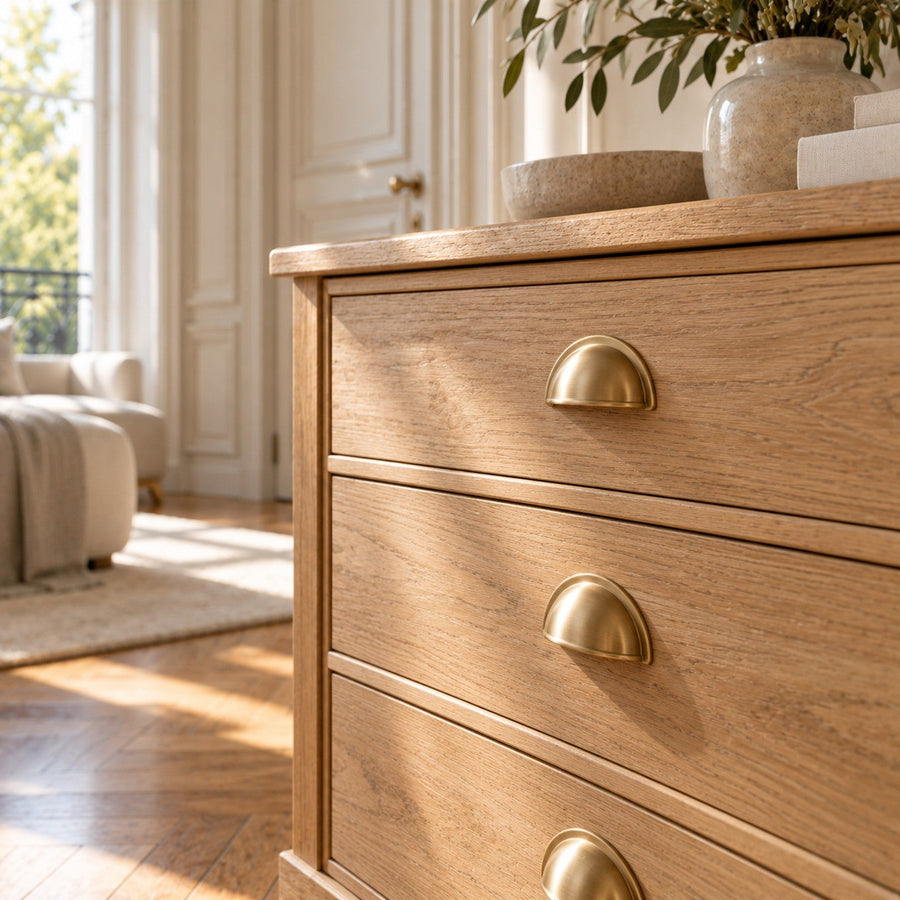 Poignées de tiroir en laiton sur une commode en chêne